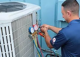 Technician reading pressure gauges connected to an air conditioning unit